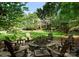Cozy backyard firepit with Adirondack chairs, a playset, lush greenery, and the rear of the house at 2324 Kingsmill Ter, Charlotte, NC 28270