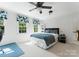 Bright bedroom features natural light from two windows, ceiling fan, and neutral carpeting at 2324 Kingsmill Ter, Charlotte, NC 28270