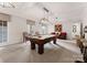 Spacious game room with a pool table under hanging pendant lights, chairs, and light gray carpet at 2324 Kingsmill Ter, Charlotte, NC 28270