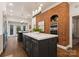 Kitchen with exposed brick wall and island, stainless steel oven and hardwood floors at 2324 Kingsmill Ter, Charlotte, NC 28270