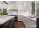 Bright kitchen featuring white cabinets, dark island, and stainless steel appliances at 2324 Kingsmill Ter, Charlotte, NC 28270