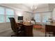 This office space includes a desk, chair, rug, chandelier, and great natural light at 2324 Kingsmill Ter, Charlotte, NC 28270