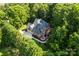 Aerial view of brick house in lush, mature landscaping with sprawling trees and a fire pit at 3011 Mckee Rd, Charlotte, NC 28270