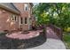 Brick patio with fire pit, landscaped yard, and brick house with stairs at 3011 Mckee Rd, Charlotte, NC 28270