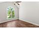 Bright bedroom featuring a ceiling fan, hardwood floors, and a large arched window at 3011 Mckee Rd, Charlotte, NC 28270