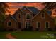 Charming brick home featuring lush lawn, manicured shrubbery, and complementary blue roofing at 3011 Mckee Rd, Charlotte, NC 28270