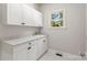 Bright laundry room featuring white cabinetry, marble countertops, and natural light at 3011 Mckee Rd, Charlotte, NC 28270