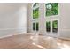 Bright living room with soaring windows, light wood floors, and access to an outdoor deck at 3011 Mckee Rd, Charlotte, NC 28270
