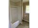 Bathroom featuring a shower with beige tile, white fixtures, and a window for natural light at 3484 S Hwy 127 Hwy, Hickory, NC 28602