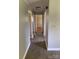 Hallway featuring laminate flooring, neutral paint, and access to multiple rooms at 3484 S Hwy 127 Hwy, Hickory, NC 28602