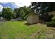 Lush backyard with green grass, storage shed, and mature trees at 416 E Union St, Marshville, NC 28103