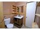 Bathroom featuring a toilet, vanity, mirror with built-in shelves, and unfinished wood trim at 416 E Union St, Marshville, NC 28103