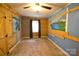 Bedroom featuring faux wood paneling, a horse painting, blue walls, and a window with curtains at 416 E Union St, Marshville, NC 28103