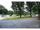 View of the front lawn with trees and a gravel driveway at 416 E Union St, Marshville, NC 28103