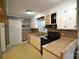 Galley kitchen featuring laminate countertops, wood backsplash, and black appliances at 416 E Union St, Marshville, NC 28103