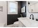 Modern bathroom with dark accent wall, white vanity, and patterned tile at 504 Wakefield Dr # A, Charlotte, NC 28209