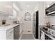 Galley kitchen with stainless steel appliances, white cabinets, and stylish backsplash at 504 Wakefield Dr # A, Charlotte, NC 28209