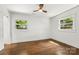 Bright bedroom features hardwood floors, a ceiling fan, and two windows providing natural light at 5320 Kildare Dr, Charlotte, NC 28215