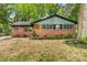 Charming brick home with a modern roof, large windows, and lush landscaping at 5320 Kildare Dr, Charlotte, NC 28215