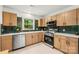 Modern kitchen with stainless steel appliances, light wood cabinets and green backsplash at 5320 Kildare Dr, Charlotte, NC 28215
