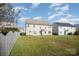 Spacious backyard view with a well-maintained lawn, partial wooden fence and neighboring homes at 5805 Lindley Crescent Dr, Indian Trail, NC 28079