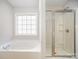 Bathroom featuring a shower with glass doors, and a soaking tub under the bright window at 5805 Lindley Crescent Dr, Indian Trail, NC 28079