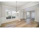 Elegant dining room with hardwood floors, wainscoting, decorative chandelier, and lots of natural light at 5805 Lindley Crescent Dr, Indian Trail, NC 28079