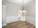 Bright dining room with hardwood floors, neutral paint, wainscotting, and modern lighting at 5805 Lindley Crescent Dr, Indian Trail, NC 28079