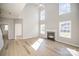 Bright and airy living room with hardwood floors, high ceilings, fireplace and large windows at 5805 Lindley Crescent Dr, Indian Trail, NC 28079