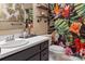 Vibrant bathroom featuring tropical-themed decor, a framed mirror, and a wooden shelf at 5922 Sullins Rd, Charlotte, NC 28214