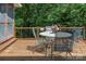 Outdoor deck features a patio table, chairs, wood flooring, and wooded views at 5922 Sullins Rd, Charlotte, NC 28214