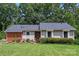 Charming ranch-style home features lush front lawn, mature trees and updated landscaping with detailed masonry facade at 5922 Sullins Rd, Charlotte, NC 28214