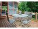 Outdoor dining space with metal table and chairs, plus view to screened porch and wooded backyard at 5922 Sullins Rd, Charlotte, NC 28214
