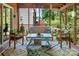 The screened-in porch has ample seating, colorful rugs, and great views of the lush backyard at 5922 Sullins Rd, Charlotte, NC 28214