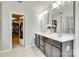 Elegant bathroom features a double vanity with large mirrors and a glimpse into a spacious walk-in closet at 6243 Kilchurn Dr, Indian Land, SC 29707
