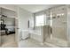 Bright bathroom showcasing a soaking tub, glass-enclosed shower, and a view into the main bedroom at 6243 Kilchurn Dr, Indian Land, SC 29707