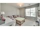 Stylish bedroom features a light pink sofa, patterned ottoman, and a well-lit desk, perfect for relaxation and study at 6243 Kilchurn Dr, Indian Land, SC 29707