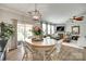 Open dining area with a modern light fixture and sliding glass doors to a deck overlooking the living room at 6243 Kilchurn Dr, Indian Land, SC 29707