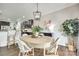 Bright dining area featuring a wooden table, stylish chairs, and a modern light fixture open to the kitchen at 6243 Kilchurn Dr, Indian Land, SC 29707