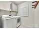 A functional laundry room is equipped with front-loading washer/dryer and ample cabinet space at 6243 Kilchurn Dr, Indian Land, SC 29707