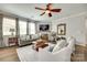 Cozy living room with a ceiling fan, fireplace, large windows, and comfortable seating area at 6243 Kilchurn Dr, Indian Land, SC 29707