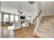 Bright and open living room adjacent to a staircase, featuring comfortable seating and a cozy fireplace at 6243 Kilchurn Dr, Indian Land, SC 29707