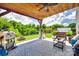 Inviting outdoor space with a wood ceiling, patio furniture, fire pit, and outdoor cooking area at 6243 Kilchurn Dr, Indian Land, SC 29707