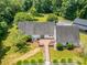 Birds-eye view of the home's rear exterior with a wooden deck, walkway, lush lawn, and mature trees at 6811 Kluttz Rd, Concord, NC 28025