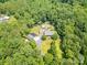 Panoramic aerial view showcasing the home's prime location amid verdant forest, garage, and in-ground pool at 6811 Kluttz Rd, Concord, NC 28025