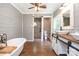 Bathroom featuring shiplap walls, dual sinks, soaking tub, and tiled shower at 6811 Kluttz Rd, Concord, NC 28025