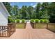 Inviting wooden deck leading to a pool, surrounded by lush greenery and a white picket fence at 6811 Kluttz Rd, Concord, NC 28025
