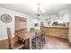 Dining room with wood table and chairs adjacent to a modern kitchen with white cabinets and stainless appliances at 6811 Kluttz Rd, Concord, NC 28025