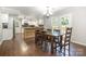 Open-concept dining area with wood flooring, table with chairs, flowing into a bright, modern kitchen at 6811 Kluttz Rd, Concord, NC 28025