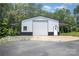 Large metal building with a sliding door and lean-to awnings, sitting on a gravel base at 6811 Kluttz Rd, Concord, NC 28025